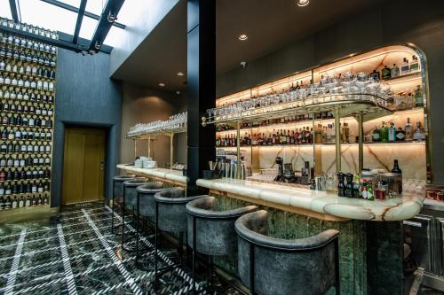 a bar with a row of bar stools at The Crown Boutique Hotel & SPA in Tirana
