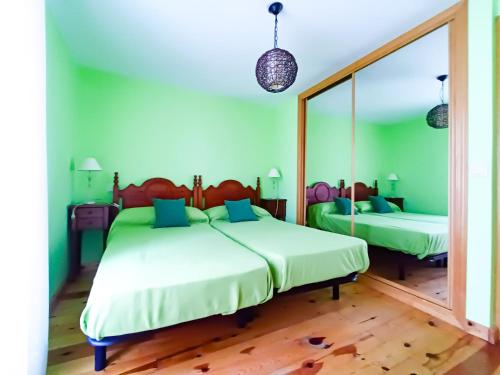 a bedroom with two beds and a large mirror at Casa rural La Antigua Herrería in Arandilla del Arroyo