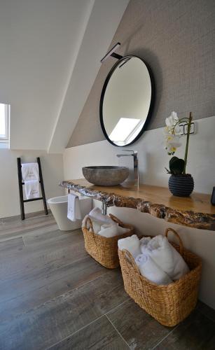 a bathroom with a sink and a mirror and baskets at GALIHOST - Casa Esclavi in Cambados