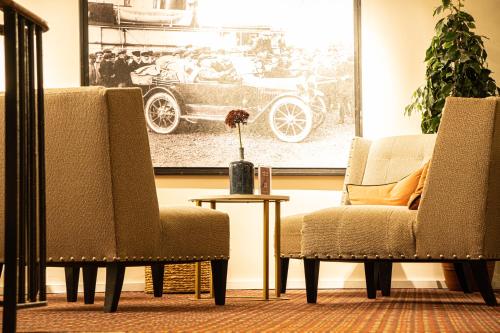a living room with two chairs and a picture of a car at Clarion Collection Hotel Grand Bodø in Bodø