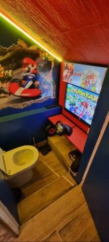 a bathroom with a toilet and a video game on the wall at Rêves de vie, suite vue mer, grande piscine privée , spa privatif in Cassis