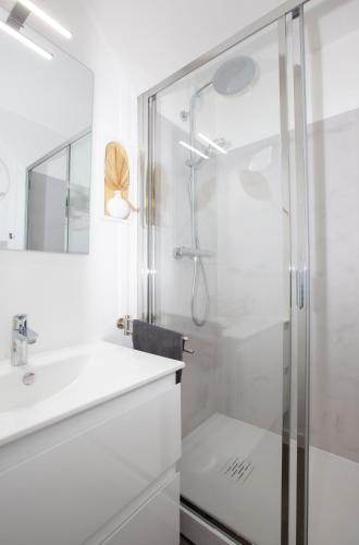 une salle de bain blanche avec une douche et un lavabo dans l'établissement La VIE EST BELLE, à Gassin