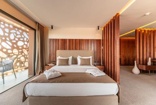 a bedroom with a large bed and a large window at Longue vie Hotels in Marrakech