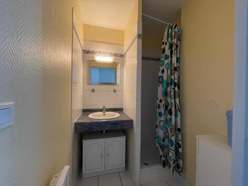 une salle de bain avec un lavabo et un miroir dans l'établissement Le Bruit Des Vagues, à Mimizan