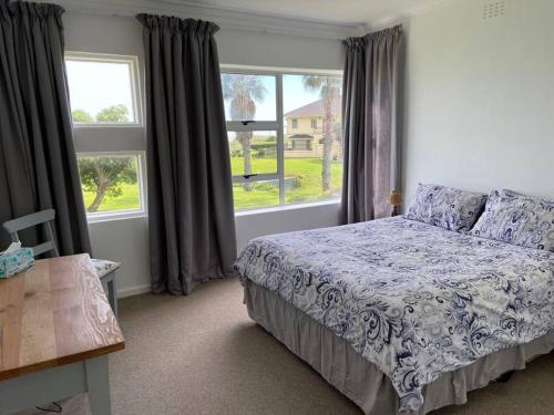 a bedroom with a bed and a large window at Sunset Paradise in Cape Town
