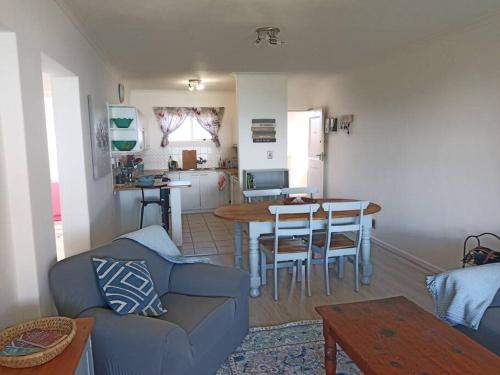 a living room with a couch and a table and a kitchen at Sunset Paradise in Cape Town