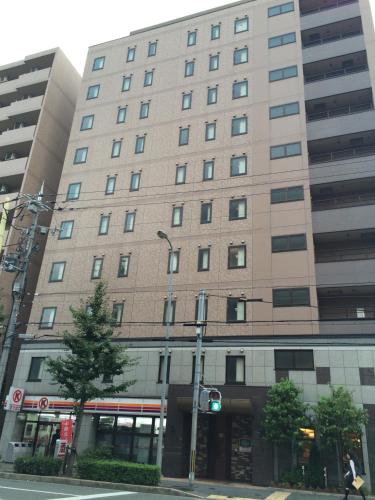 a large building on the corner of a street at Washington R&B Hotel Kyoto Station Hachijoguchi in Kyoto