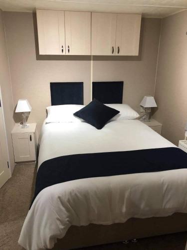 a bedroom with a large white bed with two lamps at Covesea View in Lossiemouth