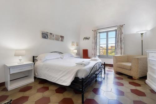 um quarto com uma cama, uma cadeira e uma janela em Trilocale Ginevra em Finale Ligure