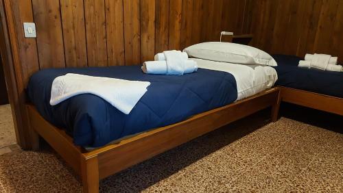 维罗纳Mansarda Romantica的房间里有两张床，上面铺着毛巾。