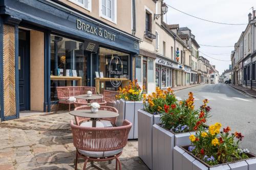 a street with tables and flowers on a city street at Break & Brut in Nogent-le-Roi