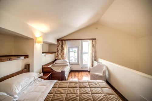 a bedroom with two beds and a window at Abbazia Collemedio Resort & Spa in Collazzone
