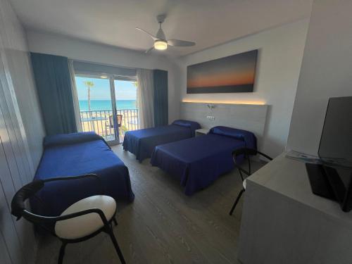 a hotel room with two beds and a balcony at Hotel Rio Mar in Peñíscola