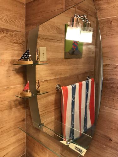 a mirror on a wooden wall with a towel at Combate Green House in Cabo Rojo
