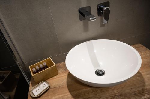 a white sink in a bathroom with a remote control at City Gallery Apartments in Trieste
