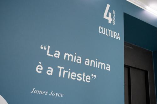a wall with a sign that says la milla anima and a triste at City Gallery Apartments in Trieste