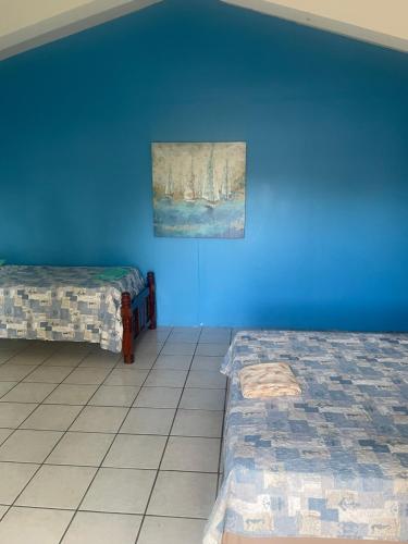 a room with two beds and a painting on the wall at Combate Green House in Cabo Rojo