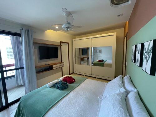 - une chambre avec un lit doté d'une télévision et d'un lit sidx sidx dans l'établissement Apart amplo e charmoso na Praia da Costa, à Vila Velha