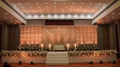 a banquet hall with a table with flowers and candles at Hotel Tip Top International Pune in Pune