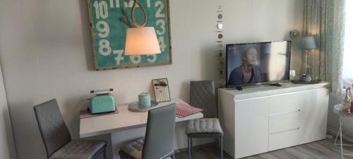 een kamer met een bureau en een televisie op een dressoir bij Cozy Tampen-Meerseite- in Neue Tiefe Fehmarn