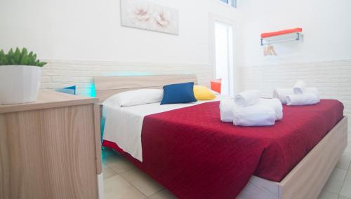a bedroom with a large bed with a red blanket at Casa Camerini by MONHOLIDAY in Villanova di Ostuni