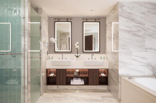 a bathroom with two sinks and a tub and a shower at The Parkgate Hotel in Cardiff