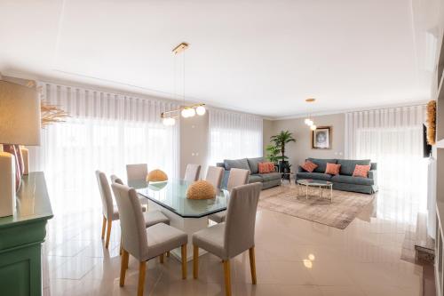 a dining room and living room with a table and chairs at Pedro Mar by Atlantic Places in Albufeira
