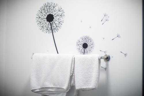 a bathroom with a towel and a flower on the wall at The Dwelling Place in Irvine