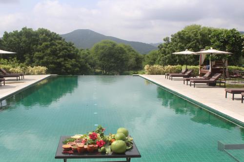 una piscina con una mesa con fruta. en Alila Fort Bishangarh Jaipur - A Hyatt Brand en Jaipur