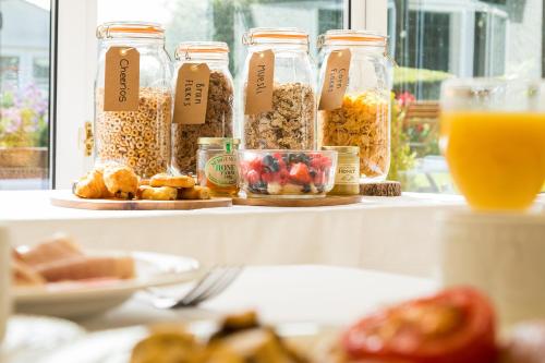 a table with jars of food and a glass of orange juice at The Lordleaze Hotel And Restaurant in Chard