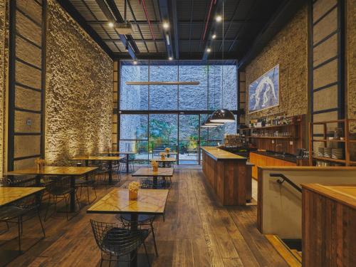 a restaurant with tables and chairs and a large window at AQ Tailored Suites in Buenos Aires