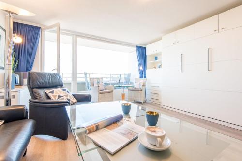 a living room with a glass table and a chair at Hanseatenhaus_ Whg_ 84 _Meerblick_ in Westerland (Sylt)