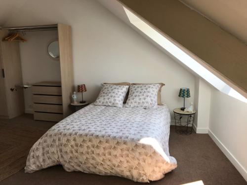 a bedroom with a large bed in a attic at Le Gîte de l'Amer - T2 - Duplex - Centre Bourg in Baden