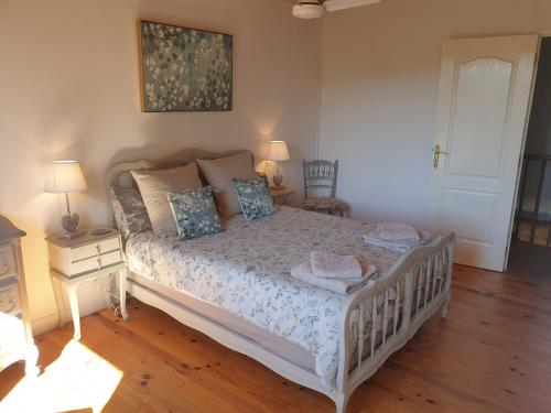 a bedroom with a white bed with a wooden floor at Chez Louis Gites in Fumel