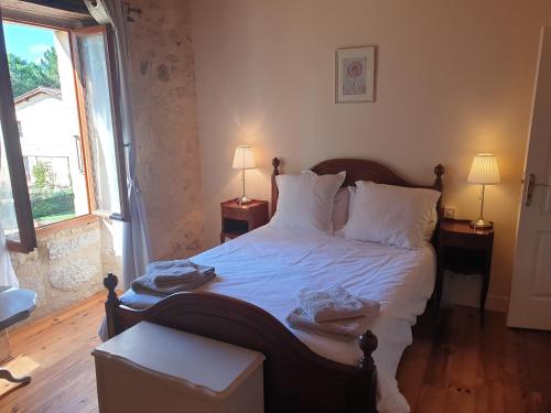 a bedroom with a large bed with white sheets and pillows at Chez Louis Gites in Fumel