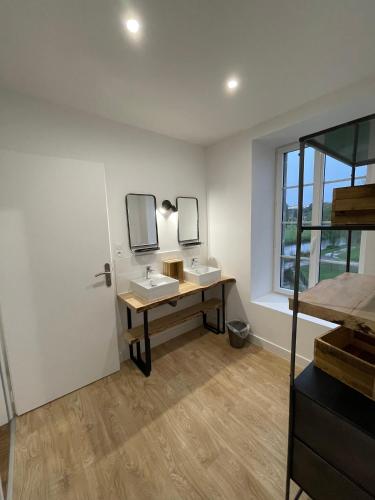a bathroom with two sinks and a desk with mirrors at Gîte moulin de Chaussac proche du Puy duFou in Saint-Laurent-sur-Sèvre
