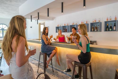 a group of people sitting at a bar at Matala Hostel in Matala