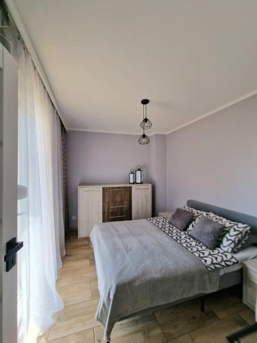 a bedroom with a large bed and a window at Apartament z basenem i ogródkiem Baltic Sun A17 in Sztutowo
