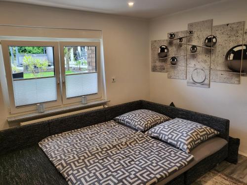 a bedroom with a bed and two windows at Ferienwohnung Saturn in Mülheim an der Ruhr