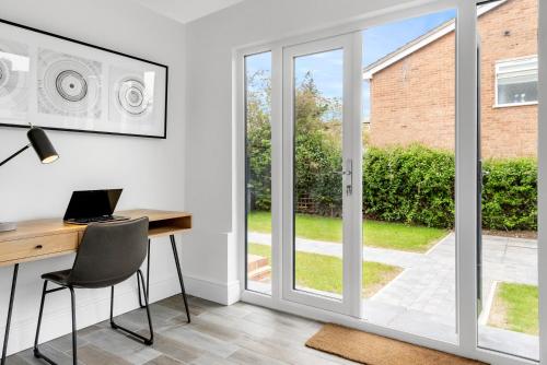 a home office with a desk and a sliding glass door at Tailored Stays - Union lane in Chesterton