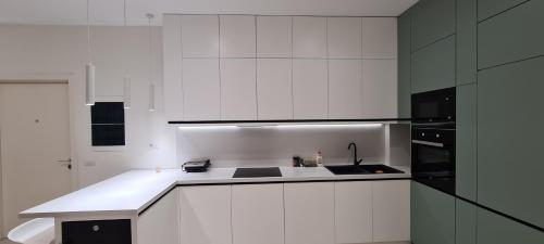 a white kitchen with a sink and a stove at Salt n Blue Villa Palase in Palasë