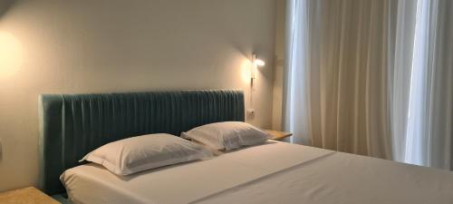 a bed with two pillows on it in a room at Salt n Blue Villa Palase in Palasë