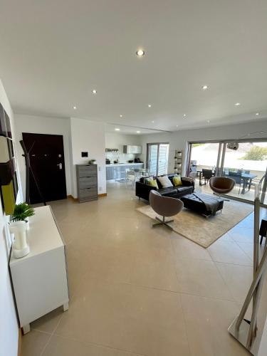 a living room with a couch and a table at Beach condo Porto mós (sea view) in Lagos