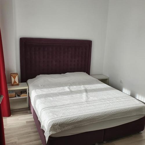 una camera con un grande letto con testiera marrone di Summerland Apartament a Mamaia