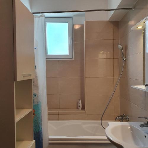 bagno con doccia, vasca e lavandino di Summerland Apartament a Mamaia