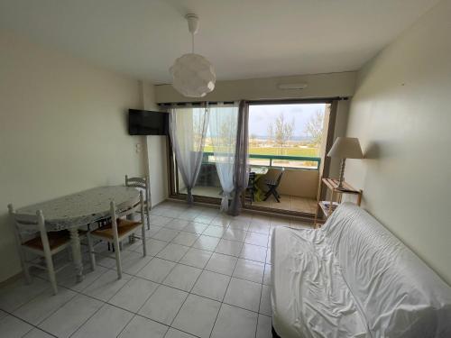 ein Wohnzimmer mit Sofa und Tisch in der Unterkunft Coconut in Mimizan