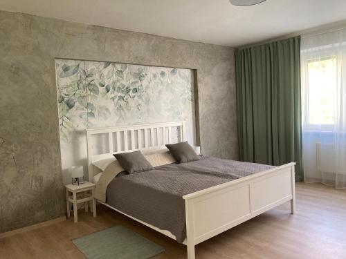 1 dormitorio con 1 cama y una pintura en la pared en Family Provence Mikulov en Mikulov