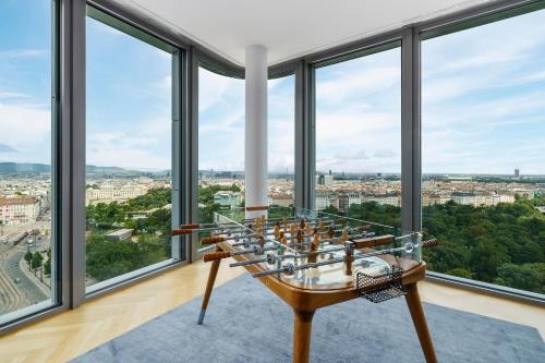 a room with large windows with a view of the city at Andaz Vienna Am Belvedere, By Hyatt in Vienna