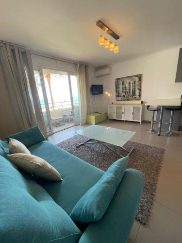 un salon avec un canapé bleu et une table dans l'établissement Fully equipped beachfront studio in the heart of the city center bd Leclerc, à Antibes