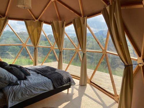 a bed in a room with a large window at Camping d'Arrouach in Lourdes